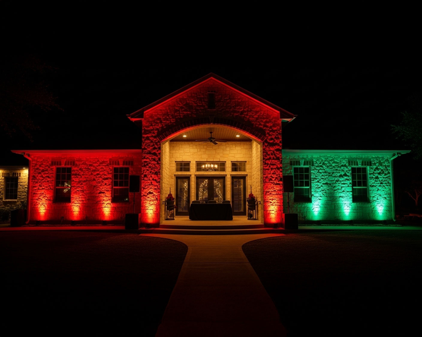 Holiday event setup at a San Antonio ranch featuring vibrant uplighting and spotlights for an enchanting atmosphere.